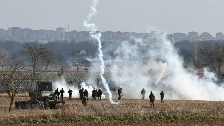 Οι Έλληνες αστυνομικοί ταραχών φρουρούν καθώς εκτοξεύονται δακρυγόνα στις Καστανιές κοντά στο συνοριακό πέρασμα Pazarkule στην Τουρκία