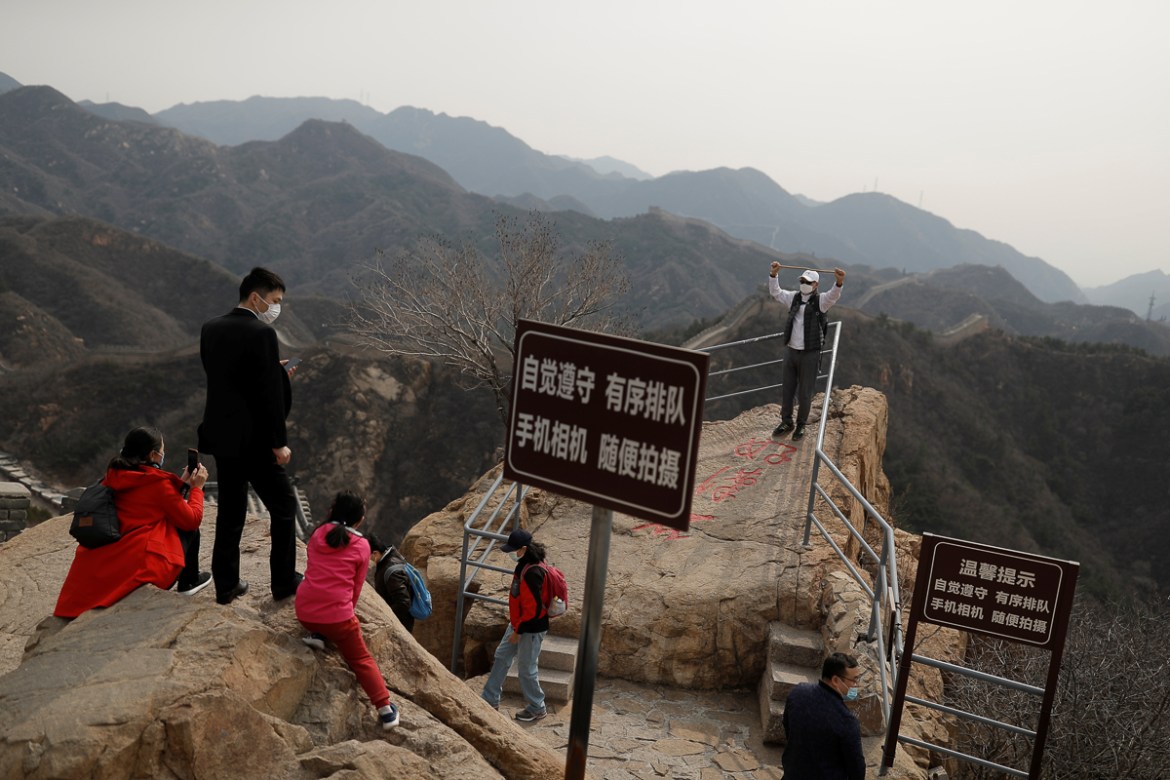 A man wearing a protective mask poses for a picture at the Great Wall in Badaling in Beijing, on its first day of re-opening after the scenic site''s coronavirus related closure, China, March 24, 2020.