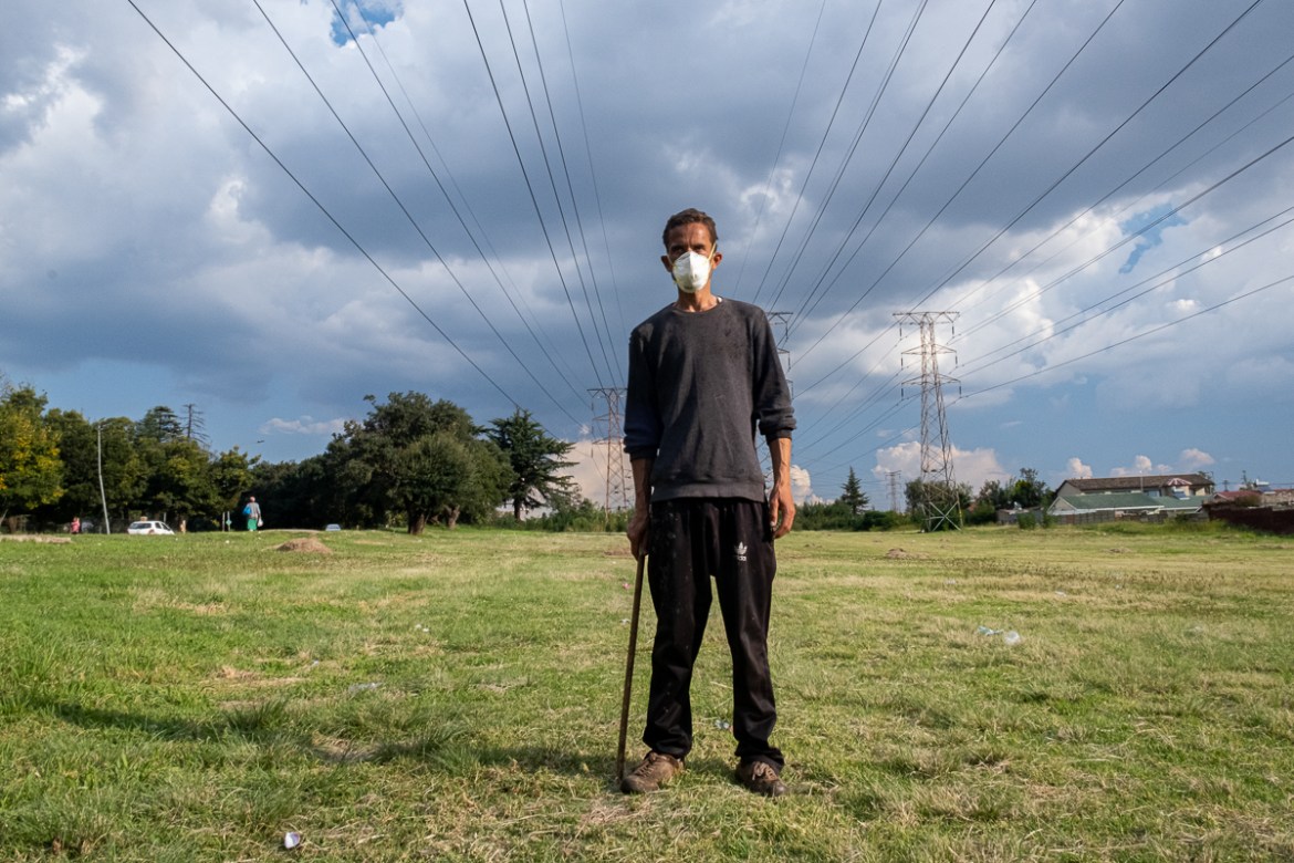 A homeless man looks on as he wears a face mask as a preventive measure against the spread of the COVID-19 Coronavirus in Johannesburg on March 20, 2020. - African countries have been among the last t