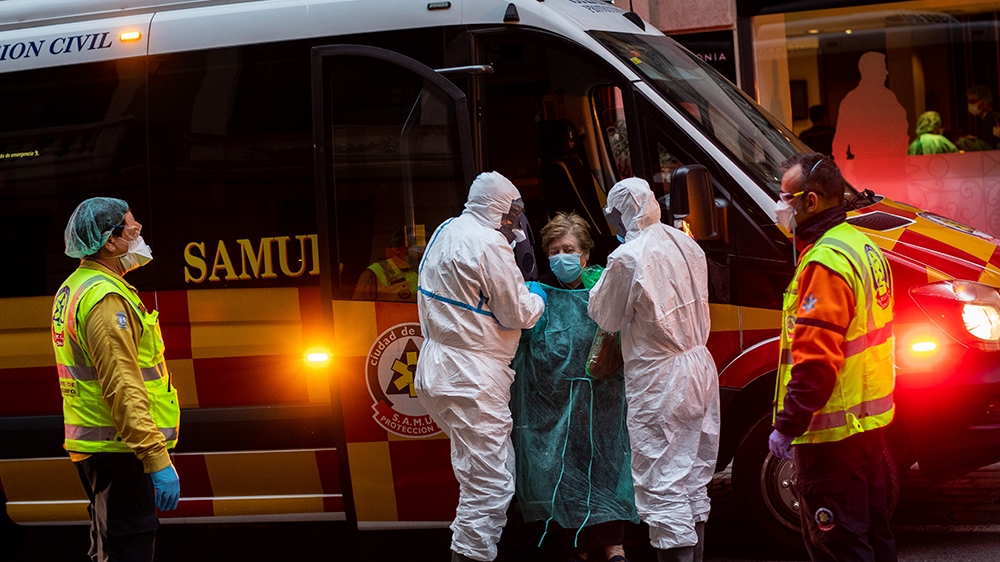 A patient, center, is transferred to a medicalised hotel during the COVID-19 outbreak in Madrid, Spain, Tuesday, March 24, 2020. For most people, the new coronavirus causes only mild or moderate sympt