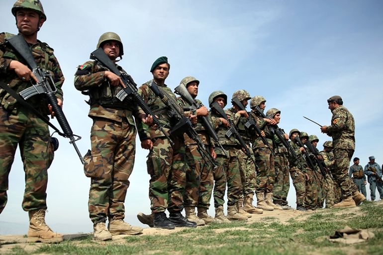 FILE - In this Tuesday, March 15, 2016 file photo, Afghan National Army soldiers stand guard, following weeks of heavy clashes to recapture the area from Taliban militants in Dand-e Ghouri district in