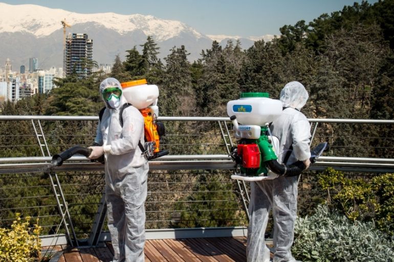Firefighters wearing protective clothing, masks and goggles, spray disinfectant on Tabia''t bridge pedestrian overpass in Tehran, Iran, on Monday, March 9, 2020. The country’s health care system, burde