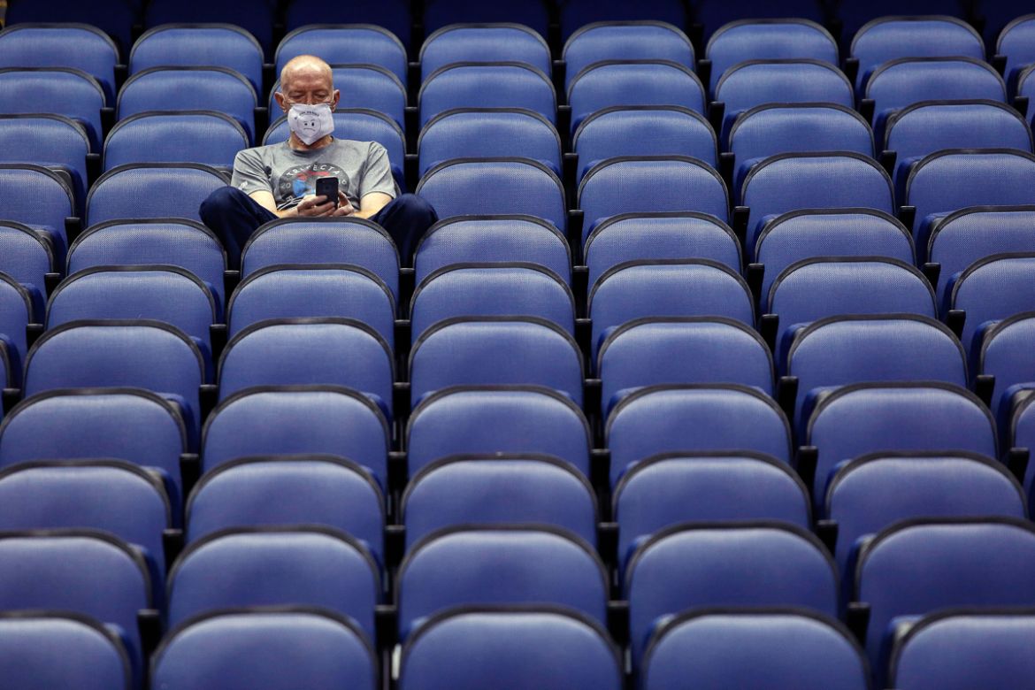 Mike Lemcke, from Richmond, Va., sits in an empty Greensboro Coliseum after the NCAA college basketball games were canceled at the Atlantic Coast Conference tournament in Greensboro, N.C., Thursday, M
