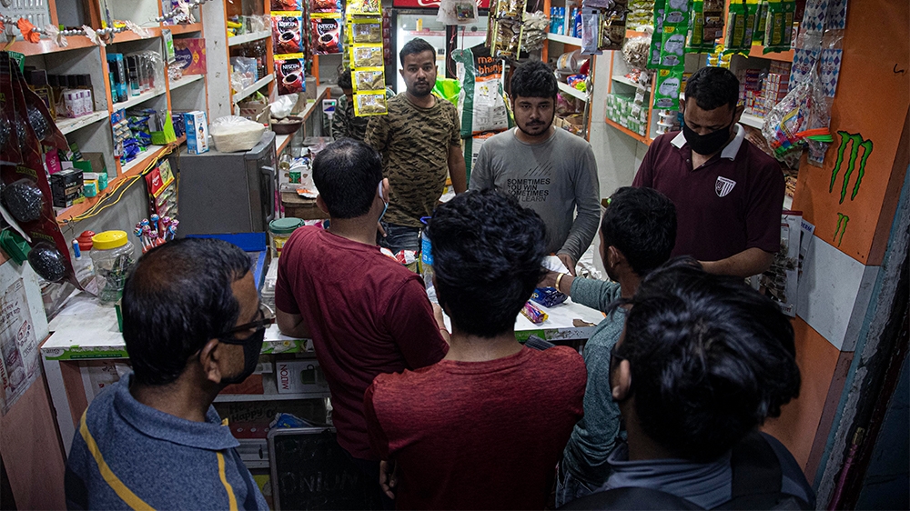 Indians buy essential commodities in a grocery shop in Gauhati, India, Tuesday, March 24, 2020. Indian Prime Minister Narendra Modi has decreed a 21-day lockdown across the nation of 1.3 billion peopl