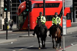 Two mounted police make their way over Westminster Bridge in London, Wednesday, March 25, 2020. British lawmakers will vote later Wednesday to shut down Parliament for 4 weeks, due to the coronavirus
