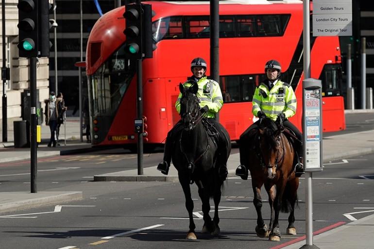 Two mounted police make their way over Westminster Bridge in London, Wednesday, March 25, 2020. British lawmakers will vote later Wednesday to shut down Parliament for 4 weeks, due to the coronavirus