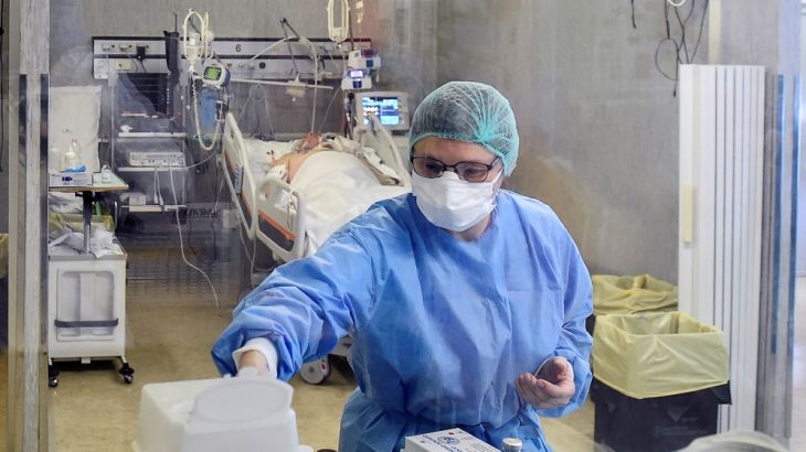 A medical worker wearing a protective mask and suit treats patients suffering from coronavirus disease (COVID-19) in an intensive care unit at the Oglio Po hospital in Cremona, Italy March 19, 2020. R