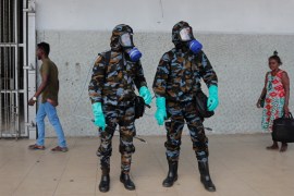 Sri Lankan government soldiers in protective clothes prepare to spray disinfectant inside a railway station in Colombo, Sri Lanka, Wednesday, March 18, 2020. For most people, the new coronavirus cause
