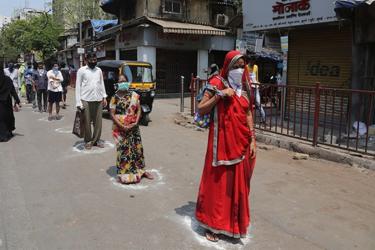 Indians stand in marked positions to buy essential commodities from a grocery store in Mumbai, India, Wednesday, March 25, 2020.The world''s largest democracy went under the world''s biggest lockdown We