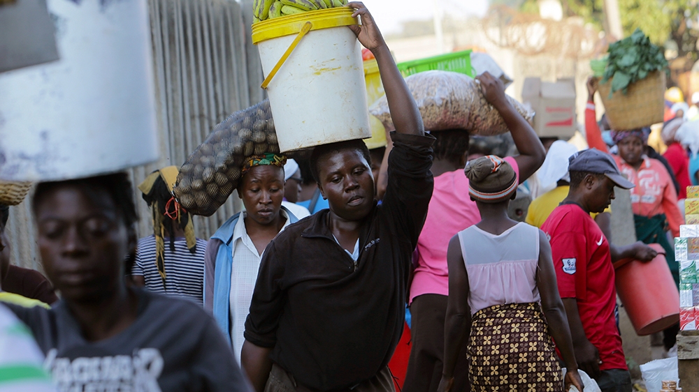 Women carry  various foodstuffs at a local market in  Harare, Zimbabwe, Friday,March, 27, 2020.Zimbabwes public hospital doctors are on strike over what they called a lack of adequate protective  gear