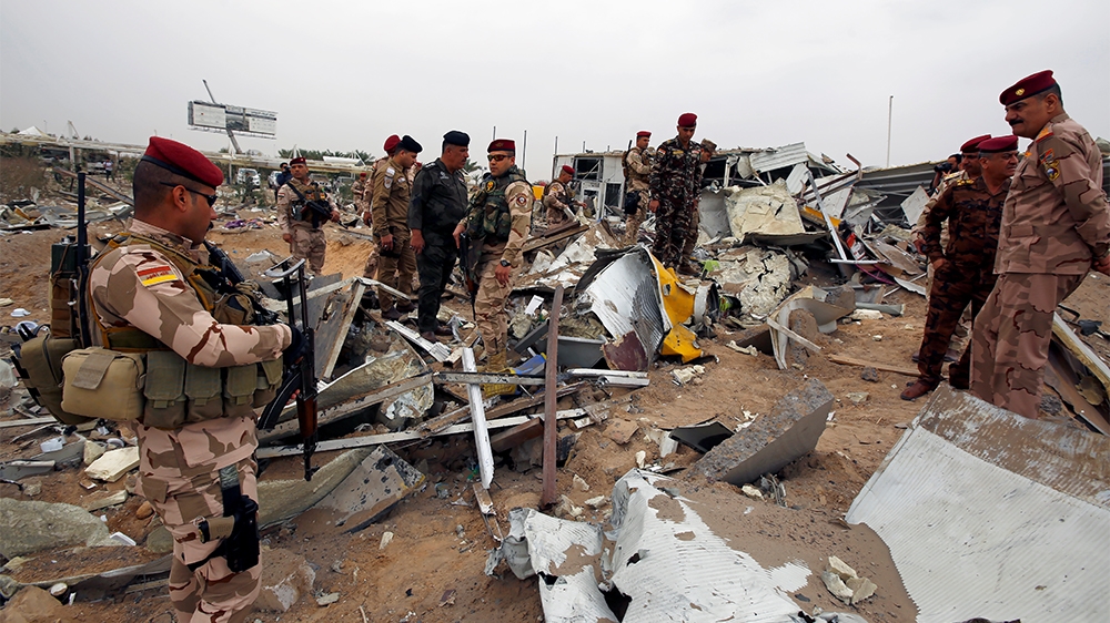 Members of Iraqi security forces check the damages a civilian airport under construction which, according to Iraqi religious authorities, was hit by a U.S. air strike, in the holy Shi'ite city of Kerb