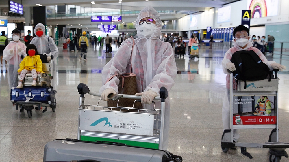 Passengers wear protective suits, amid the outbreak of coronavirus, at Hong Kong International Airport, Hong Kong, China March 17, 2020. REUTERS/Tyrone Siu