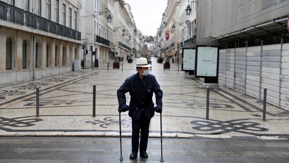A tourist wearin a protective mask as a preventive measure against coronavirus disease (COVID-19) walks at Augusta street in downtown Lisbon