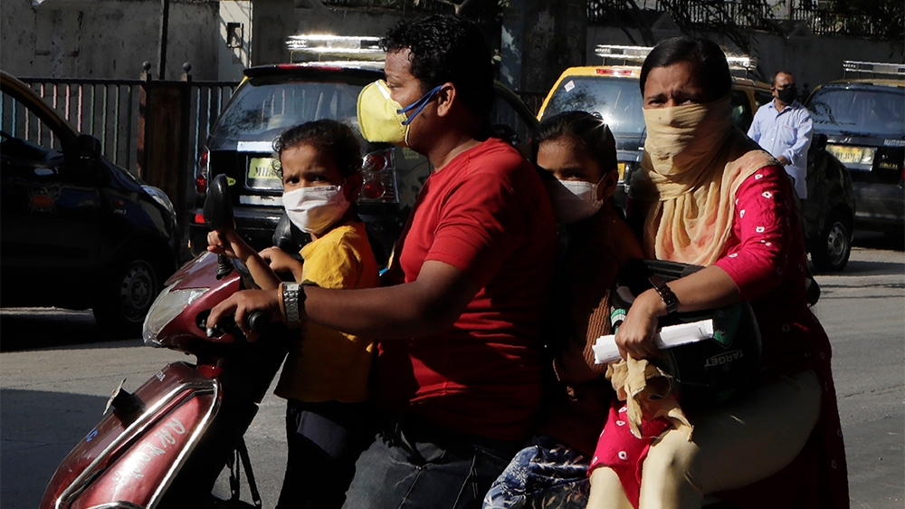 People wear protective masks as a precautionary measure following the Coronavirus pandemic in Mumbai, India, Tuesday, March 17, 2020. (AP Photo/Rajanish Kakade)
