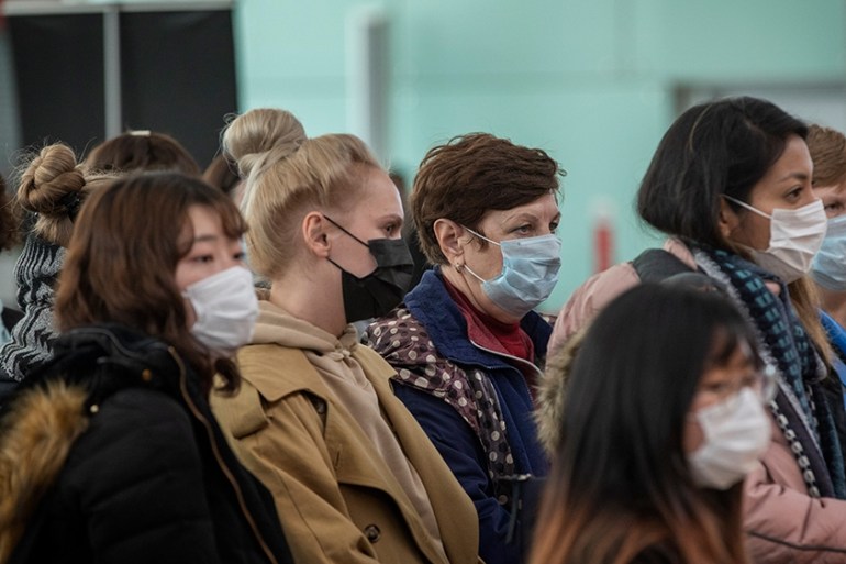 Passengers wearing masks line up as they wait to check in at the Barcelona airport, Spain, Saturday, March 14, 2020. Spain''s prime minister has announced a two-week state of emergency from Saturday in