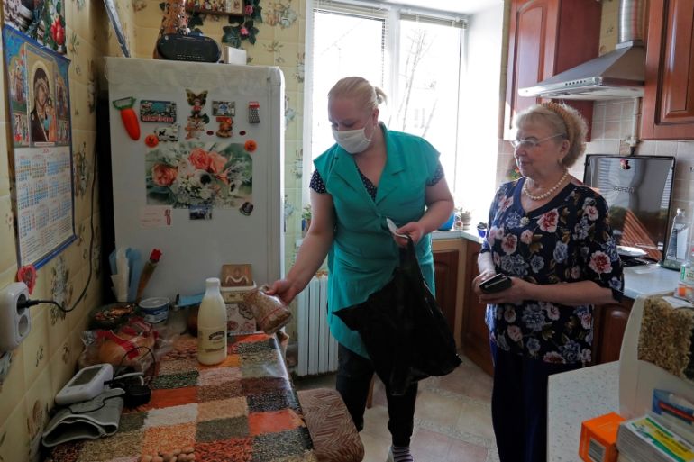 A social worker hands over the purchased food to a local resident amid coronavirus disease (COVID-19) outbreak in Minsk
