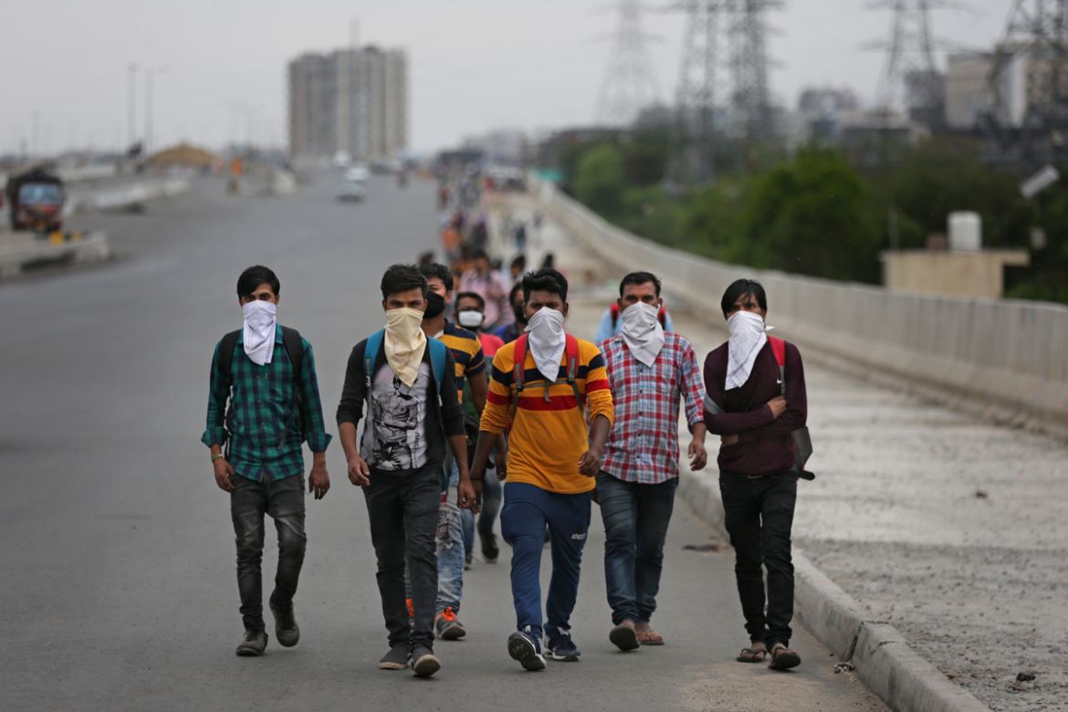 A group of Indian daily wage laborers walk along an expressway hoping to reach their homes, hundreds of kilometers away, as the city comes under lockdown in Ghaziabad, on the outskirts of New Delhi, I