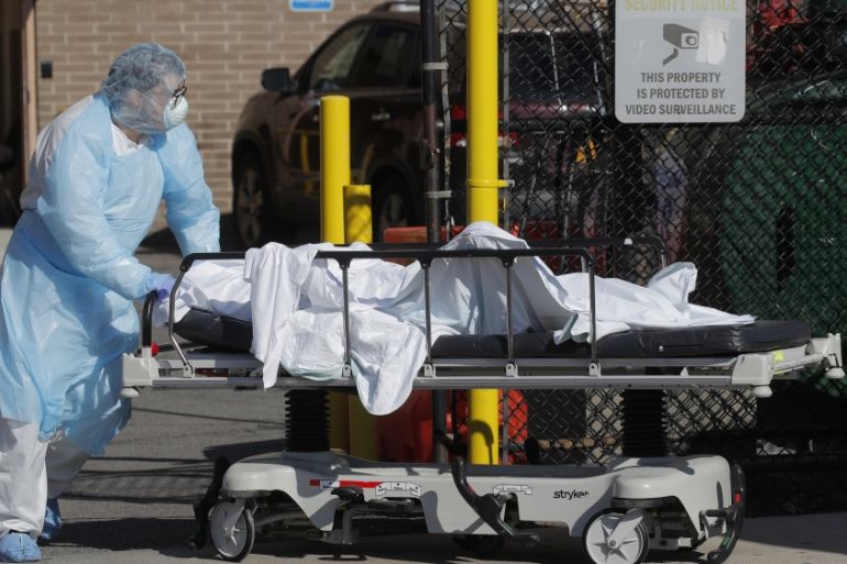Healthcare worker wheels body of deceased person from Wyckoff Heights Medical Center during outbreak of coronavirus disease (COVID-19) in New York
