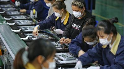 Employees, wearing masks, work on a production line manufacturing display monitors at a TPV factory in Wuhan, Hubei province, the epicentre of the novel coronavirus disease (COVID-19) outbreak in Chin