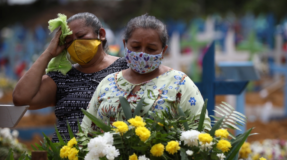 Women react during a collective burial of people that have passed away due to the coronavirus disease (COVID-19), at the Parque Taruma cemetery in Manaus, Brazil April 28, 2020. REUTERS/Bruno Kelly