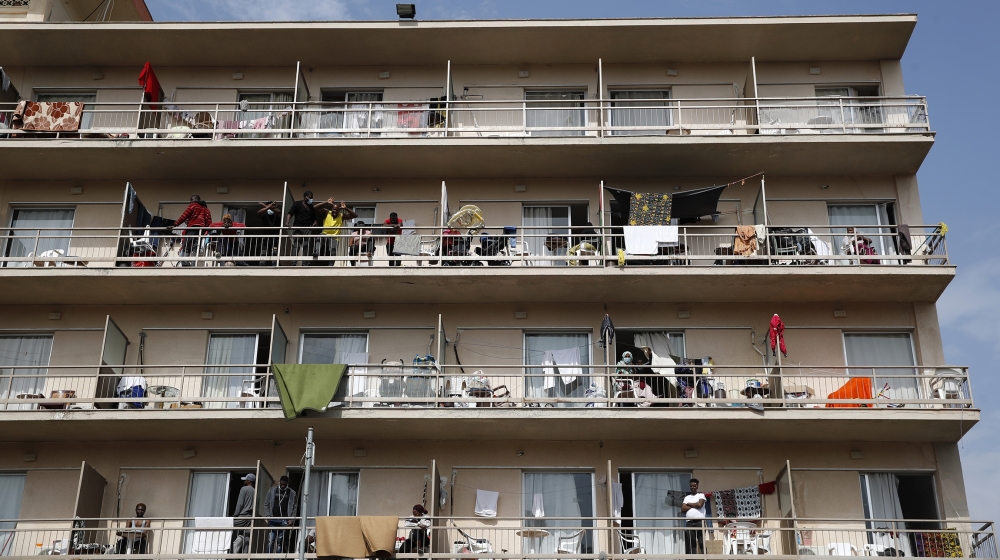 Migrants gather on their balconies at a hotel in Kranidi town about 170 kilometers (106 miles) southwest of Athens, Tuesday, April 21, 2020. The heads of Greece's pandemic response effort are visiting