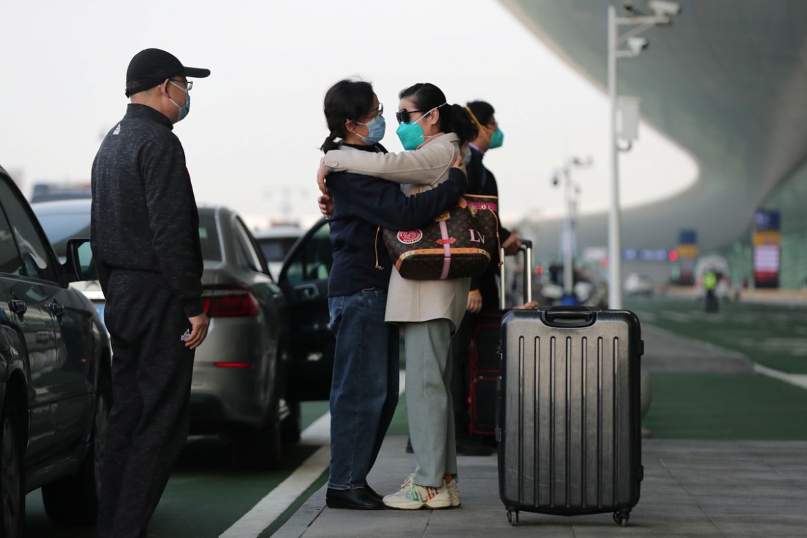 A traveller wearing a face mask hugs a woman outside Wuhan Tianhe International Airport, after travel restrictions to leave Wuhan, the capital of Hubei province and China''s epicentre of the novel coro
