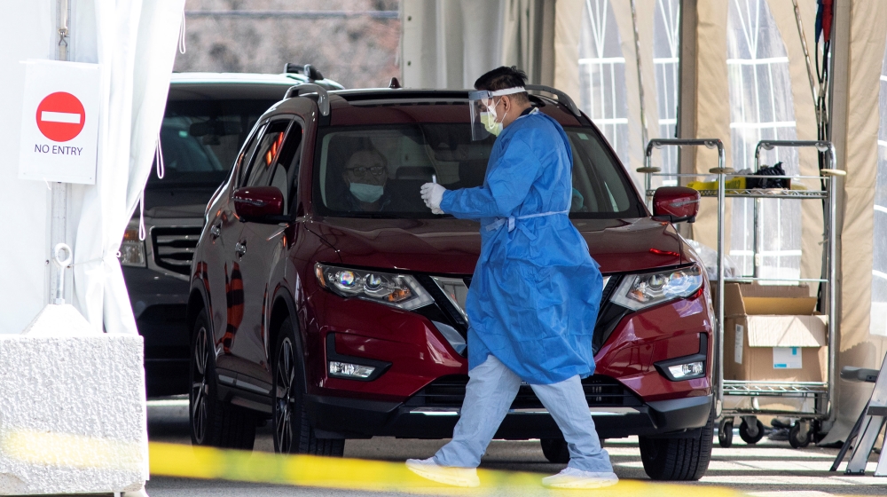 A frontline healthcare worker attends people at the Etobicoke General Hospital drive-thru COVID-19 assessment centre as the number of coronavirus disease (COVID-19) cases continue to grow, in Toronto,