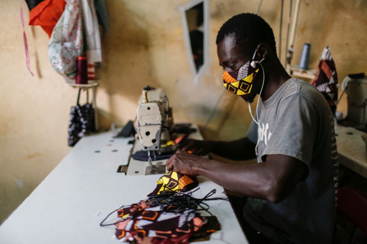 A tailor in a western Dakar neighborhood where a high number of coronavirus cases has been recorded sews double-layered masks made from African print fabric. Although Dakar is not facing a shortage of