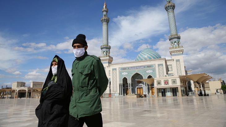 A couple wearing protective face masks, following the outbreak of coronavirus disease (COVID-19), walks on the street in Qom, Iran March 24, 2020. Picture taken March 24, 2020. WANA (West Asia News Ag