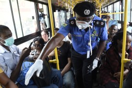 Lagos Commissioner of Police, Hakeem Odumosu (C), speaks to passengers to enforce social distancing in a bus as part of measures to curb the spread of the COVID-19 coronavirus in Lagos, Nigeria on Mar