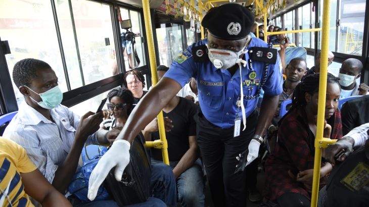 Lagos Commissioner of Police, Hakeem Odumosu (C), speaks to passengers to enforce social distancing in a bus as part of measures to curb the spread of the COVID-19 coronavirus in Lagos, Nigeria on Mar