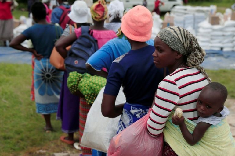 Villagers queue to collect food aid distributed by the World Food Program (WFP) following a prolonged drought in rural Mudzi district, Zimbabwe, February 20, 2020.