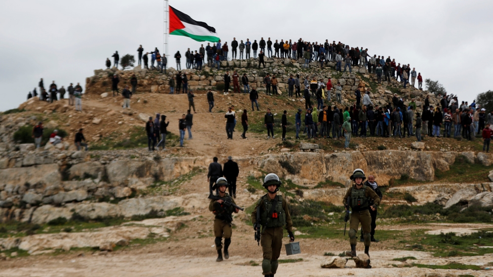 Israeli forces stand guard as Palestinian demonstrators gather during a protest against Israeli settlements in Beita town near Nablus in the Israeli-occupied West Bank
