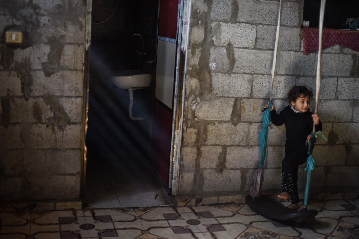 A girl having a good time swinging inside her house in Khan Yunis refugee camp. Gazan parents are trying to provide entertainment inside homes to ensure children don’t go out to play in the street.