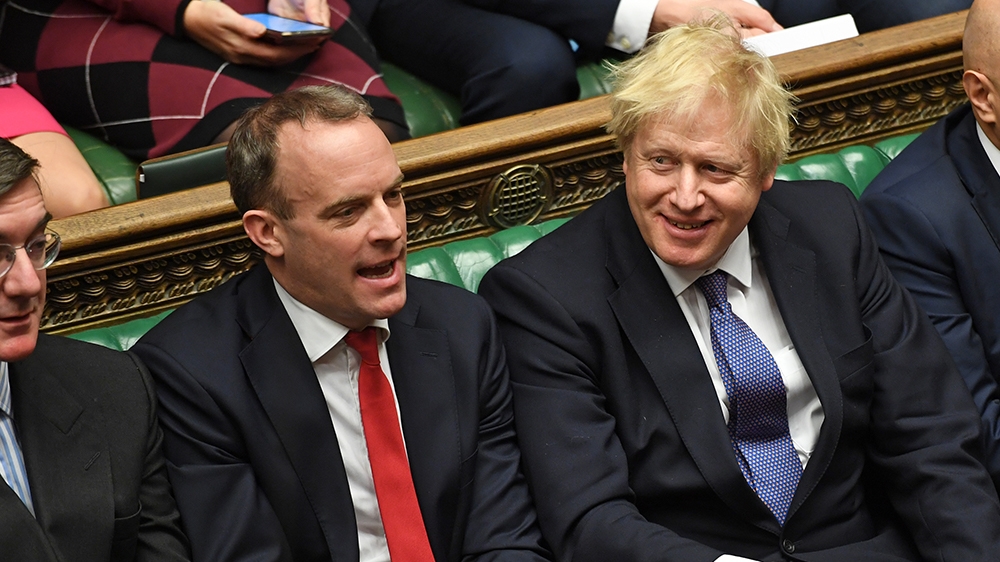 A handout photograph released by the UK Parliament shows Britain's Prime Minister Boris Johnson (C) smiling beside (L-R) Britain's Leader of the House of Commons J