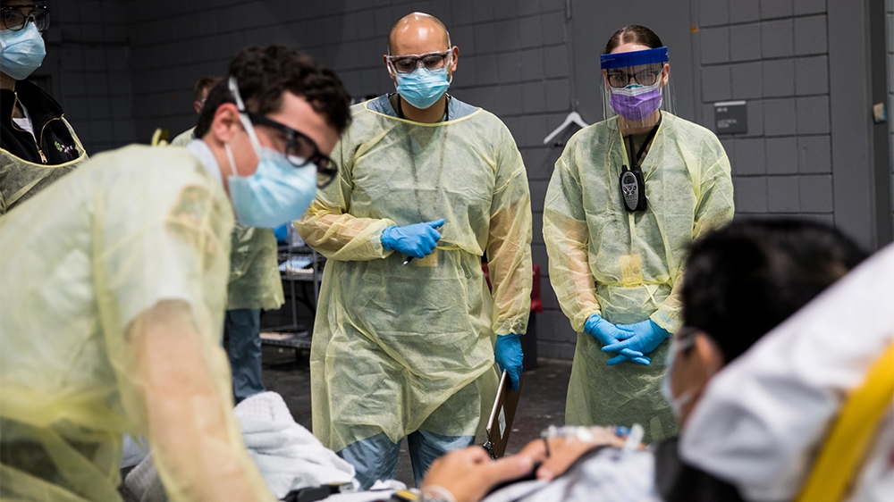 Soldiers assigned to Javits New York Medical Station conduct check-in procedures on an incoming coronavirus disease (COVID-19) patient with local emergency workers in the facility’s medical bay in New