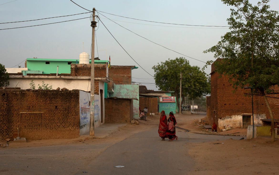 Women walk through an empty street during nationwide lockdown in India to slow the spread of the coronavirus, in Jugyai village in the central state of Madhya Pradesh, India, April 8, 2020. Picture ta