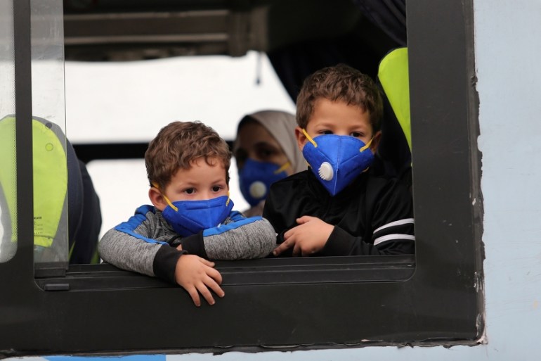 Children wearing protective face masks are pictured on a bus, following the outbreak of coronavirus disease (COVID-19), in Algiers
