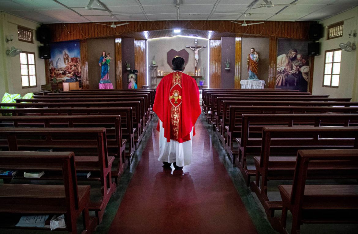 A Catholic priest V.M. Thomas enters a church for a special prayer on Good Friday in Gauhati, India, Friday, April 10, 2020. People around the world have begun celebrating Good Friday and Easter from