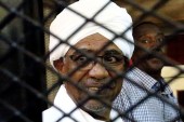 Sudan's former president Omar Hassan al-Bashir sits inside a cage at the courthouse where he is facing corruption charges, in Khartoum on September 28, 2019 [File: Mohamed Nureldin Abdallah/Reuters]