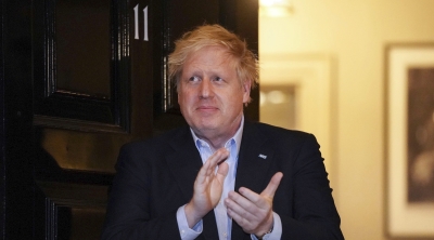 In this handout photo provided by 10 Downing Street, Britain's Prime Minister Boris Johnson claps outside 11 Downing Street to salute local heroes during Thursday's nationwide Clap for Carers NHS in