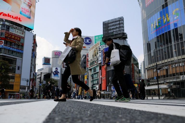 Less than usual pedestrians cross the Shibuya crossing after the government announced the state of emergency for the capital following the coronavirus disease outbreak in Tokyo, Japan