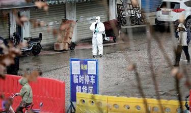 A worker in a protective suit is seen at the closed seafood market in Wuhan