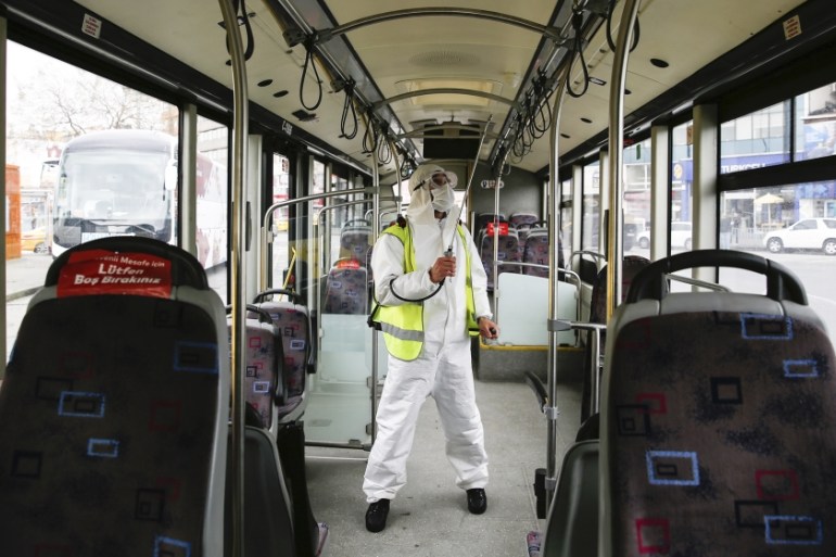 A municipality worker wearing a protective suit sprays disinfectant on a bus in Istanbul, amid the coronavirus outbreak, Friday, April 3, 2020. The new coronavirus causes mild or moderate symptoms for