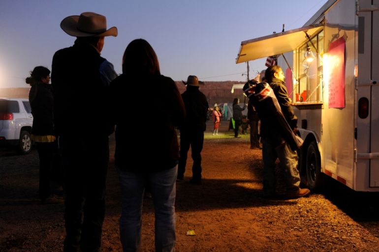 People wait for food from a mobile vendor at the Utah Navajo Fair in Bluff, Utah