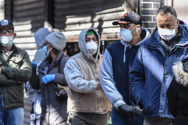 NEW YORK, NY - APRIL 1: People stand in line while wearing face masks in the Elmhurst neighborhood on April 1, 2020 in New York City. With more than 75,000 confirmed cases of COVID-19 and more than 1,