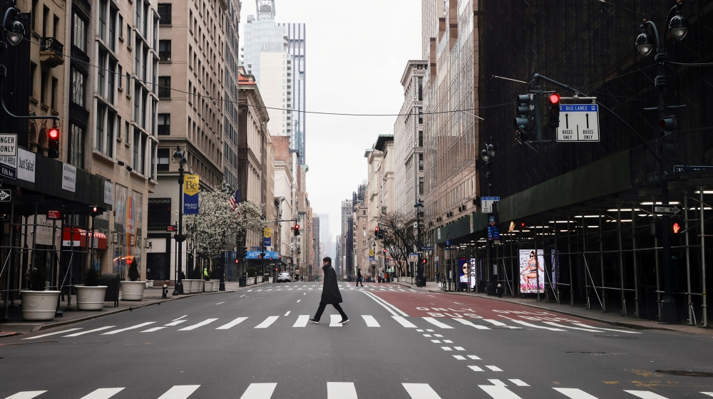 A man crosses a nearly empty 5th Avenue in midtown Manhattan during the outbreak of the coronavirus disease (COVID-19) in New York City, New York, U.S., March 25, 2020. REUTERS/Mike Segar TPX IMAGES O
