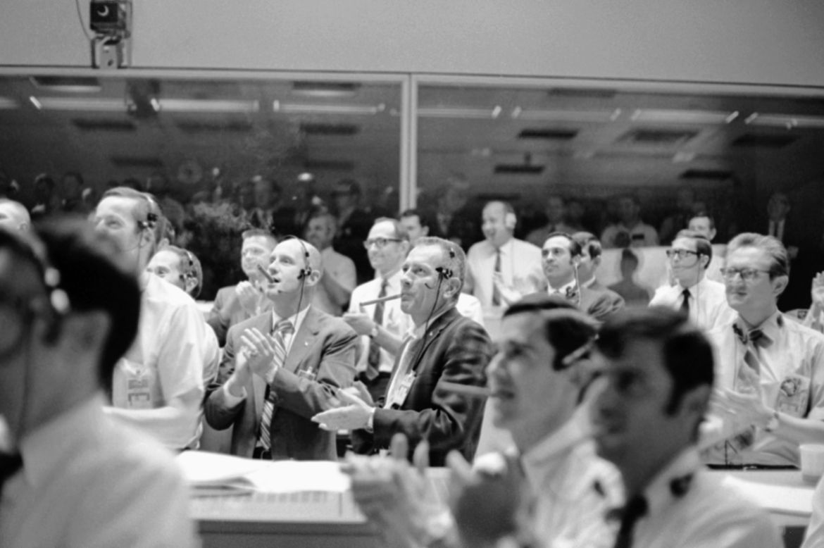 Astronaut Thomas Stafford, left, and Donald Slayton, Director of Flight Crew Operations, puff on big cigars and applaud as the Apollo 13 made a successful splashdown, April 17, 1970, Houston, Tex. Oth
