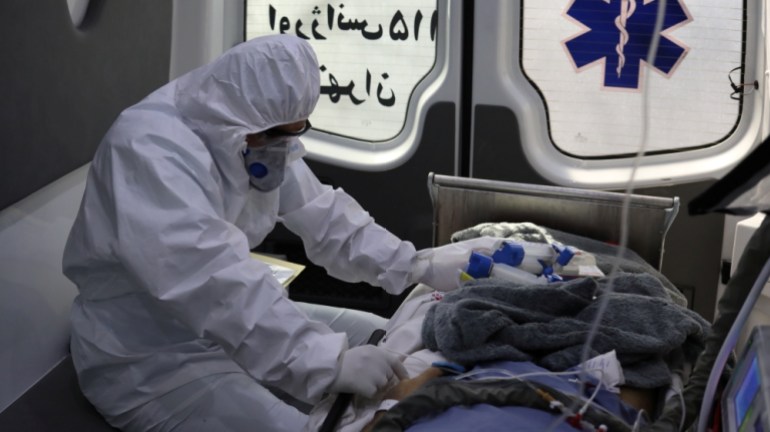 A member of emergency medical staff wearing protective suit, sits in an ambulance while transferring a patient with coronavirus disease (COVID-19) to Masih Daneshvari Hospital, in Tehran