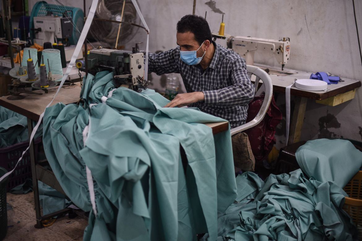 A Palestinian worker sews protective clothing inside a factory in Sheikh Radwan in Gaza City.
